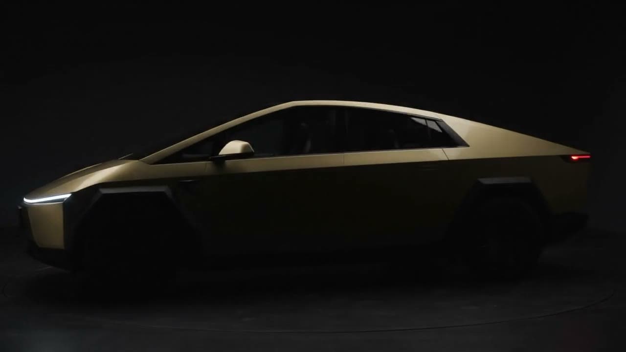 Gold Cybercab in profile against a dark studio background.